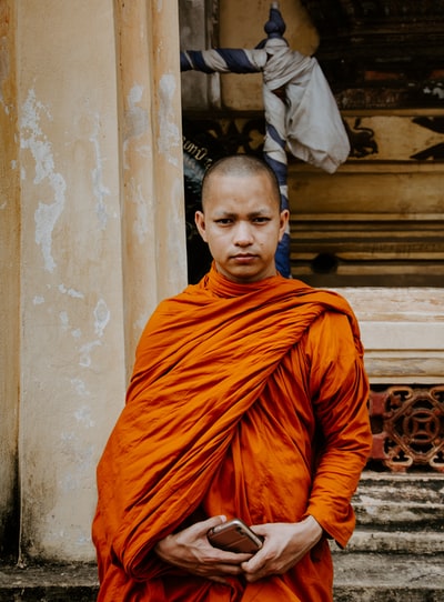 Monks holding a smartphone standing in front

